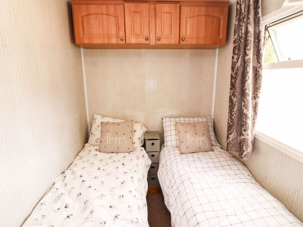 A bedroom with two beds and a wall cabinet at Summer Breeze in Clitheroe