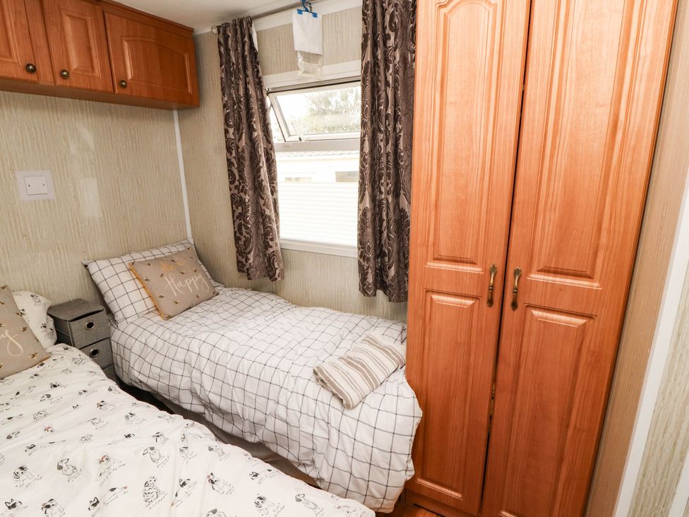 A bedroom with beds and a wardrobe at Summer Breeze in Clitheroe