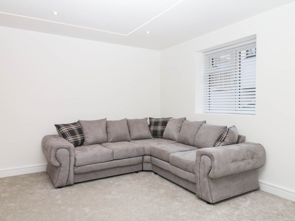 A living room with a grey sofa and window at Greenswood Mews in Brixham
