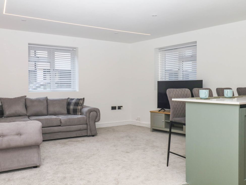 A living room with a sofa and television at Greenswood Mews in Brixham