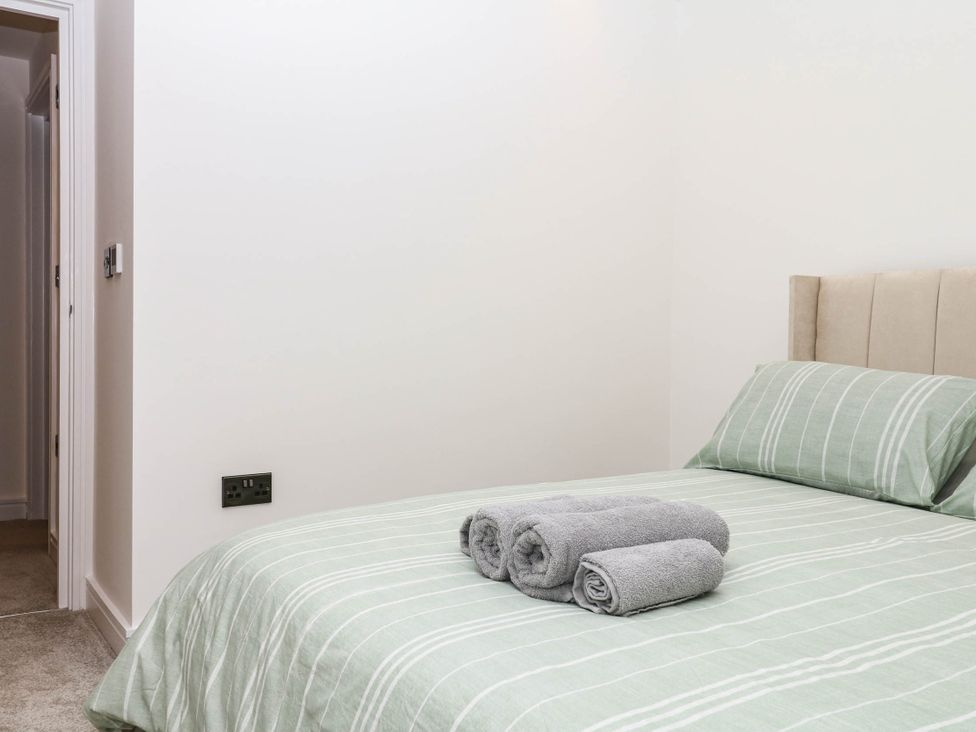A bedroom with a bed and towels at Greenswood Mews in Brixham