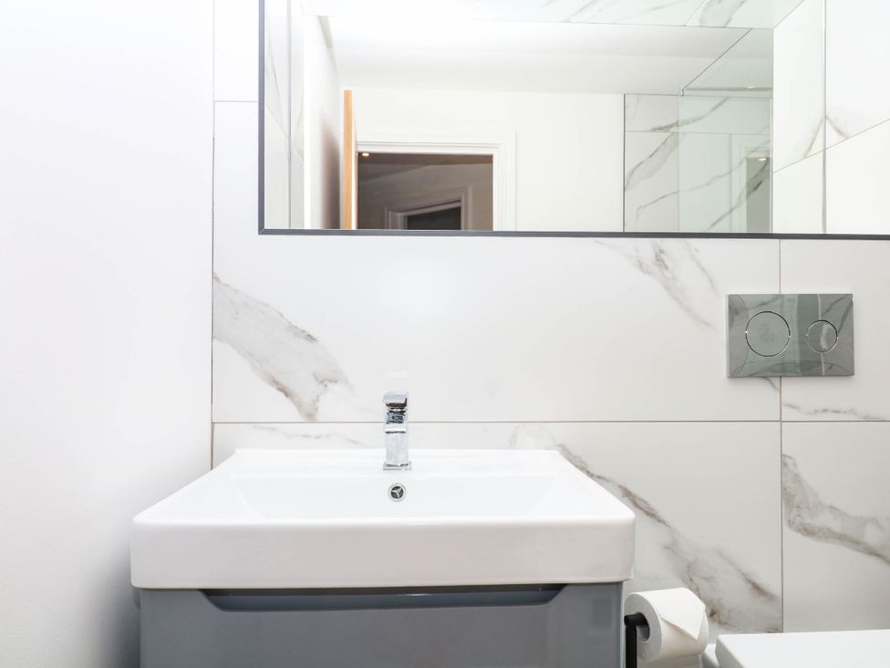 A bathroom with a sink and mirror at Greenswood Mews in Brixham