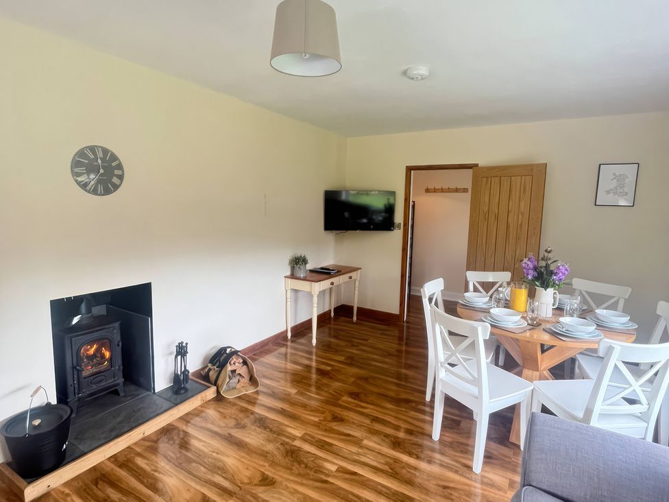 A dining room with a table and chairs at Saddleback Bungalow in Llandrindod Wells