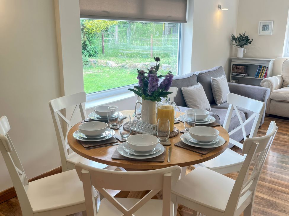 A dining table set with plates and glasses at Saddleback Bungalow in Llandrindod Wells
