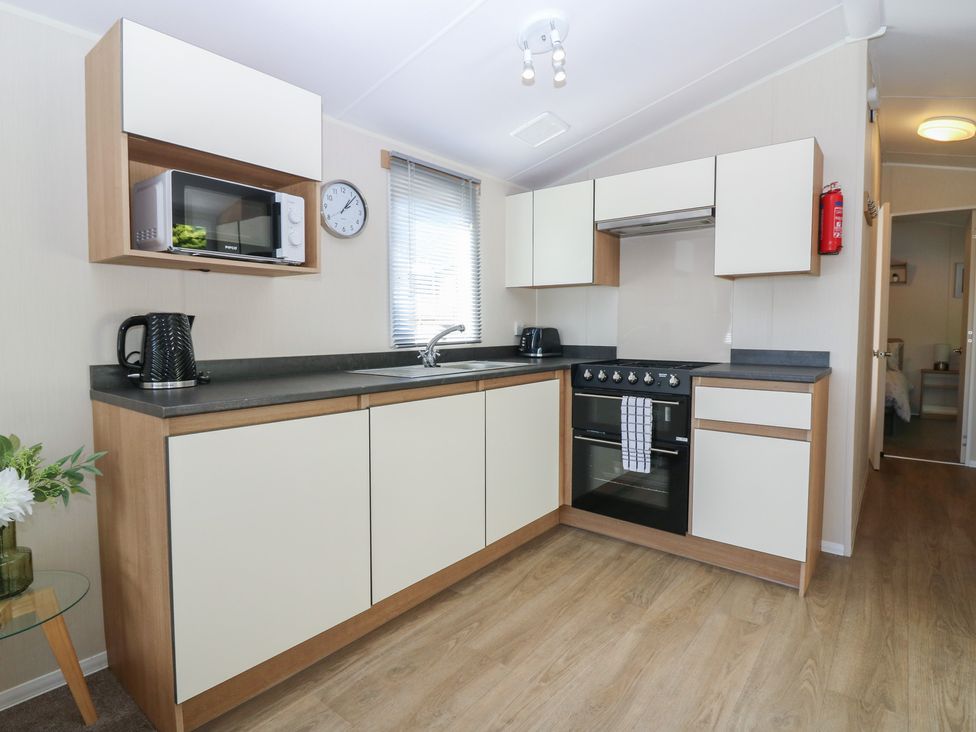 A kitchen with a microwave, kettle, cooker and sink at NO. 249 Eyemouth