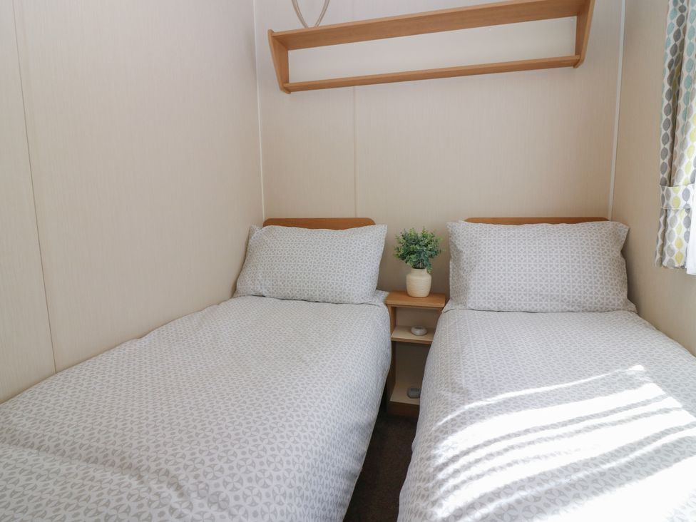 A bedroom with two single beds and a small shelf at NO. 249 Eyemouth