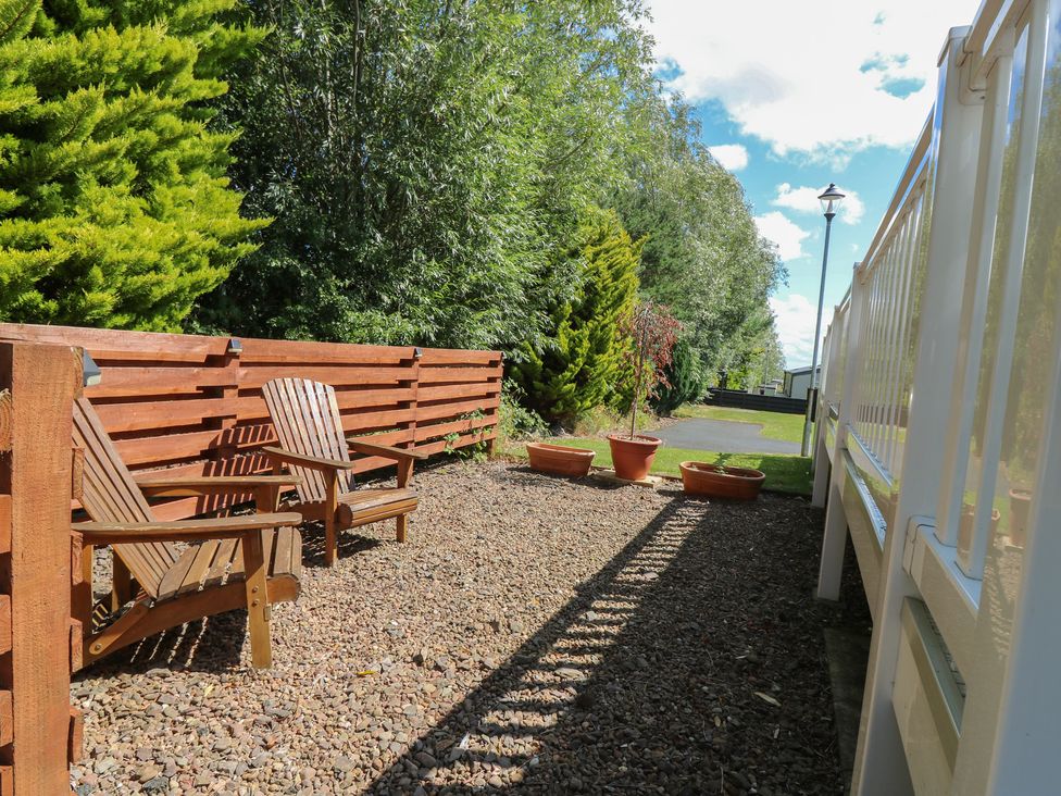 A garden with deck chairs and potted plants at NO. 249 Eyemouth