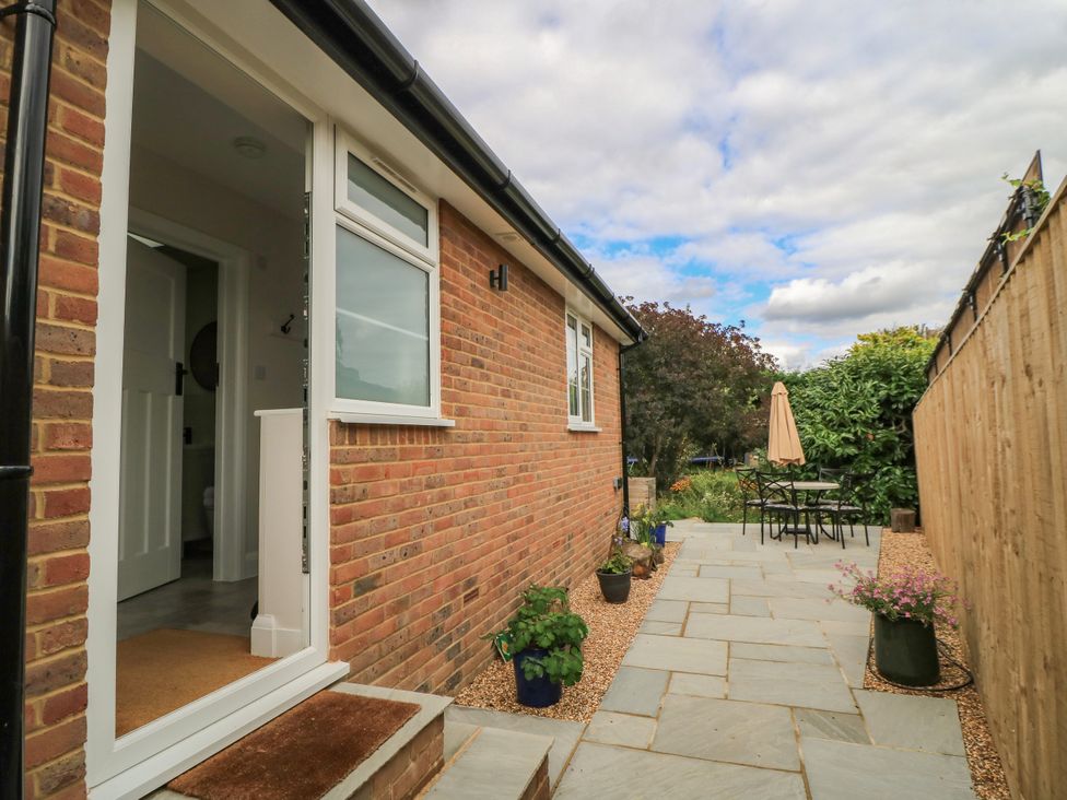 A garden with a patio and table set at Kingswick Lodge Naphill
