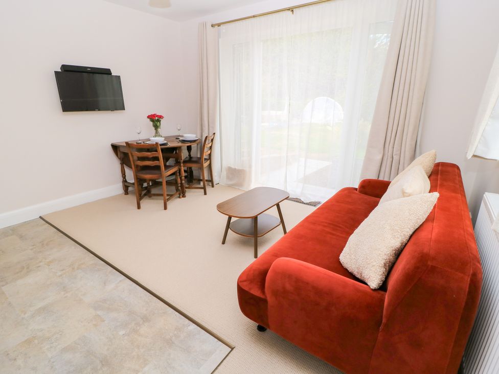 A living room with a dining table and sofa at Kingswick Lodge Naphill
