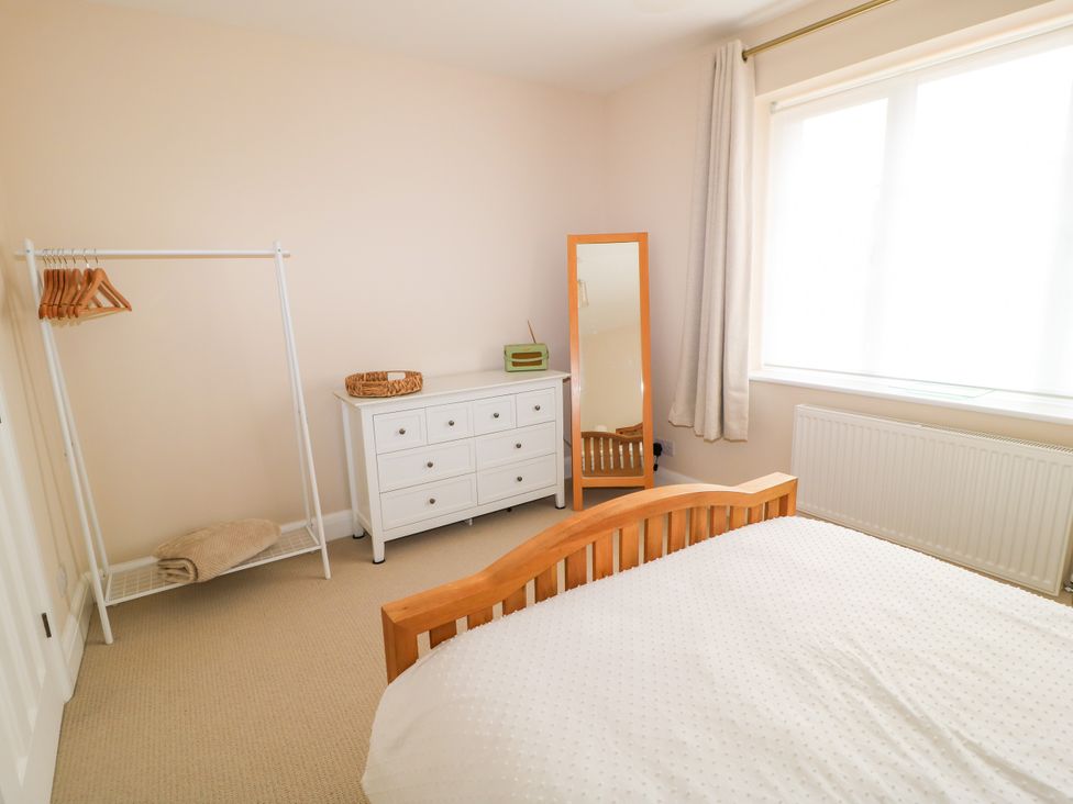 A bedroom with a bed, dresser, and mirror at Kingswick Lodge in Naphill