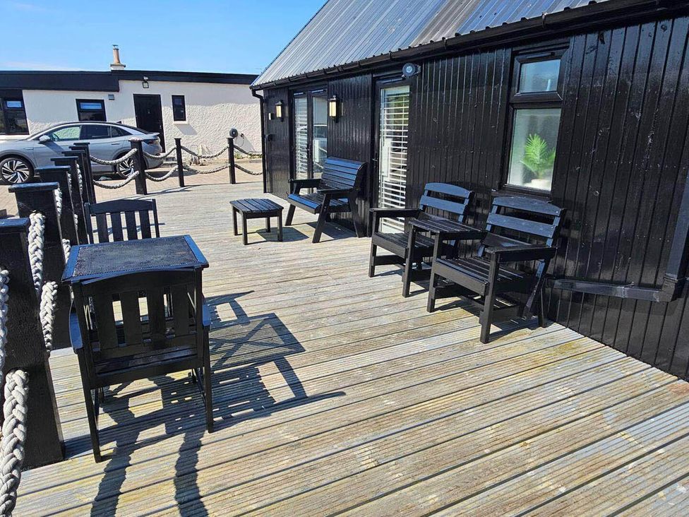 An outdoor area with black chairs and a table at 2 Bed Cottage Sleeps 4 Harbour Sea View, Cruden Bay