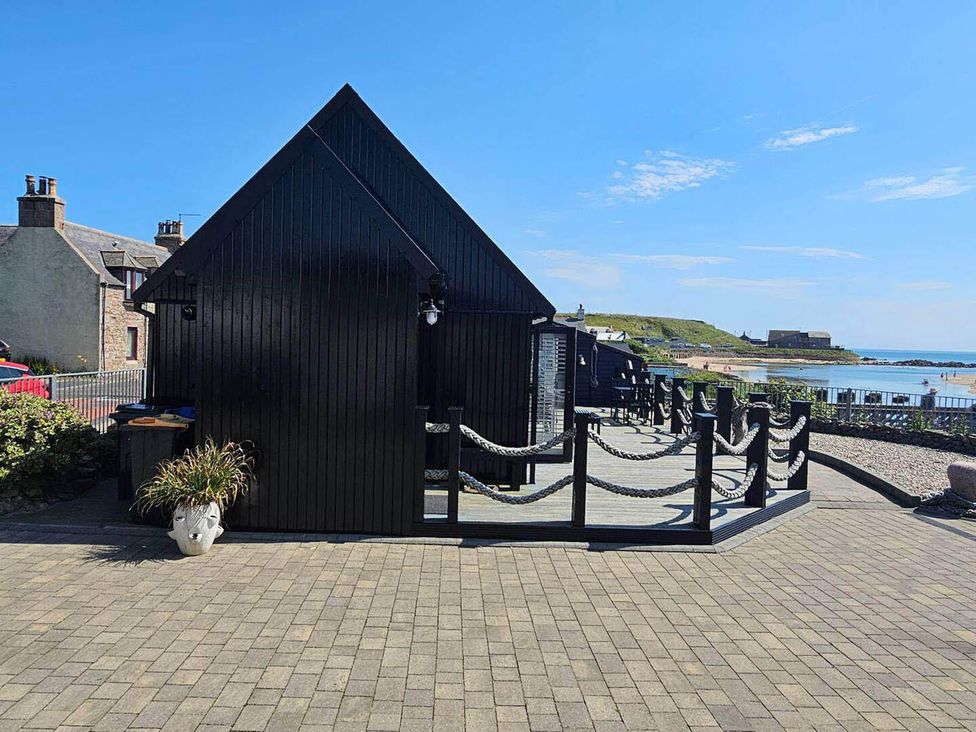 A black cabin with a sea view at 2 Bed Cottage Sleeps 4 Harbour Sea View in Cruden Bay
