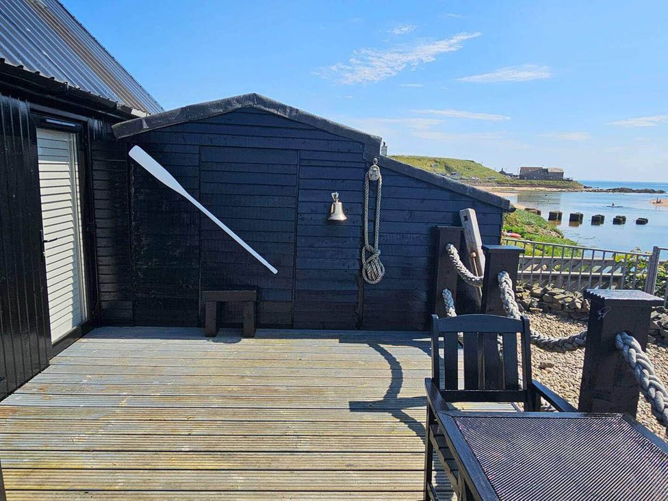 An outdoor area with a deck, an oar, and a bell at 2 Bed Cottage Sleeps 4 Harbour Sea View Cruden Bay