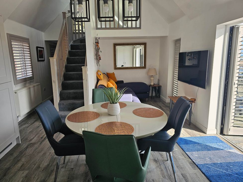 A living room with a dining table and chairs at 2 Bed Cottage Sleeps 4 Harbour Sea View Cruden Bay