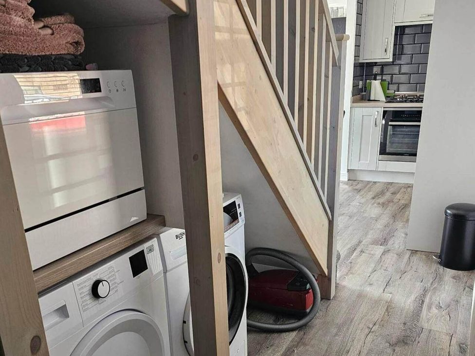 A utility room with washing machine, dryer, and vacuum cleaner at 2 Bed Cottage Sleeps 4 Harbour Sea View in Cruden Bay