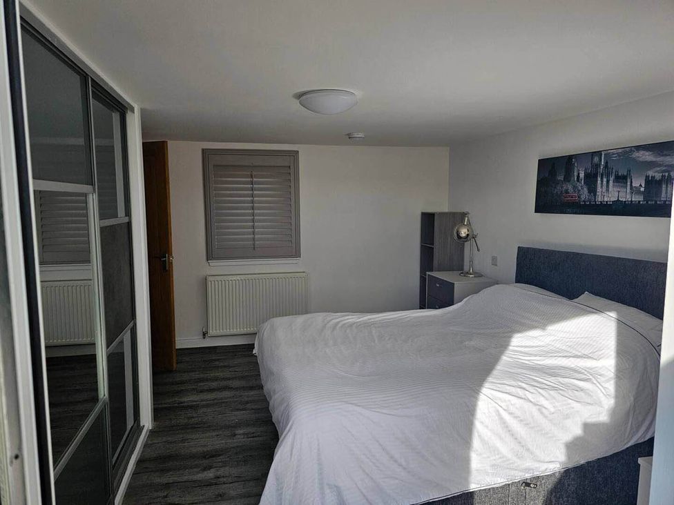 A bedroom with a bed and lamp at 2 Bed Cottage Sleeps 4 Harbour Sea View Cruden Bay