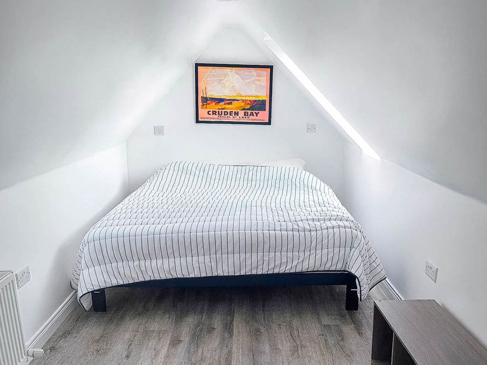 A bedroom with a bed and wall art at 2 Bed Cottage Sleeps 4 Harbour Sea View, Cruden Bay