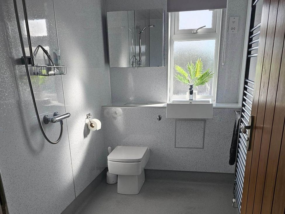A bathroom with a sink, toilet, and shower at 2 Bed Cottage Sleeps 4 Harbour Sea View, Cruden Bay