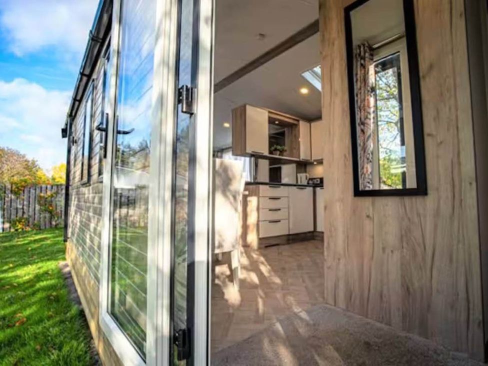 A kitchen with a window and door at Findhorn Lodge Peaceful Sleeps 4 in Forres
