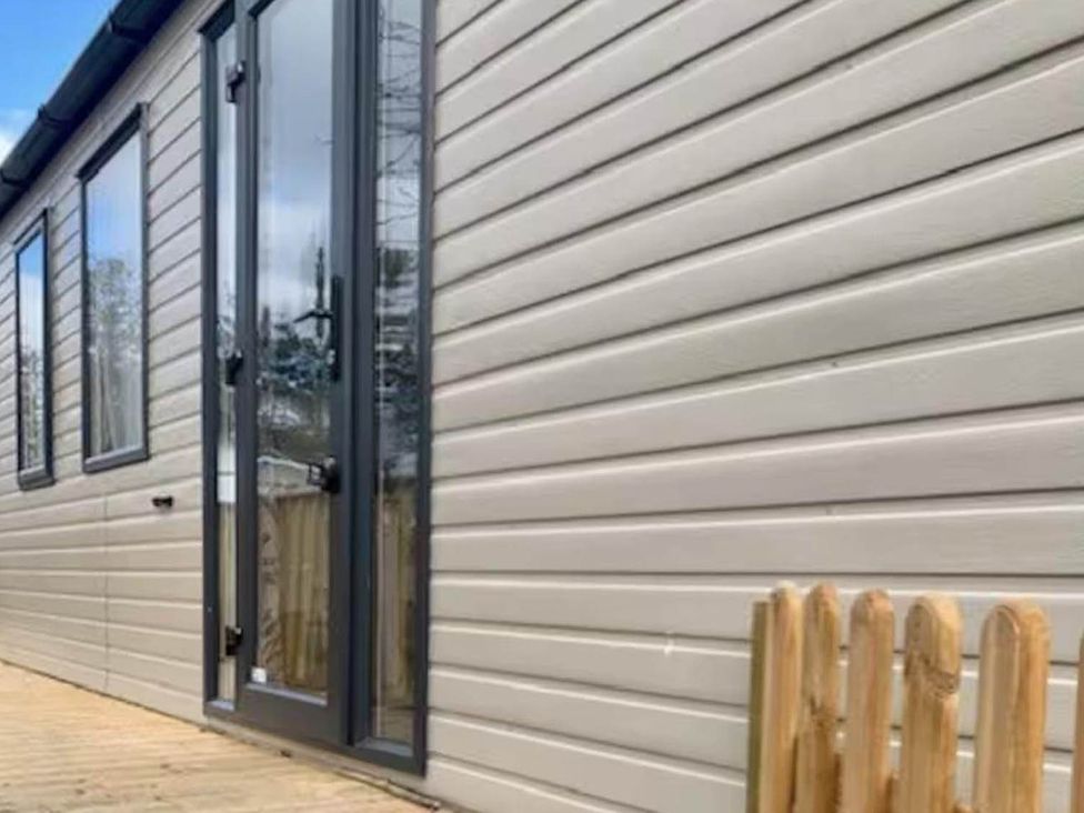 An exterior view of a cabin with windows and a door at Findhorn Lodge Peaceful Sleeps 4 in Forres