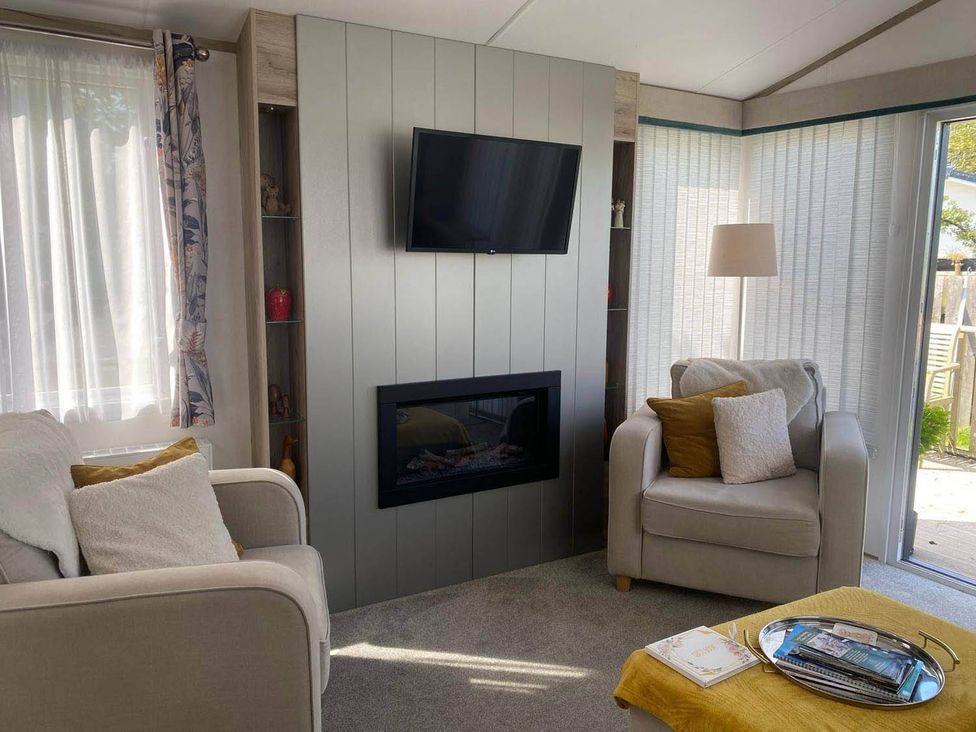 A living room with a TV and fireplace at Findhorn Lodge Peaceful Sleeps 4 in Forres