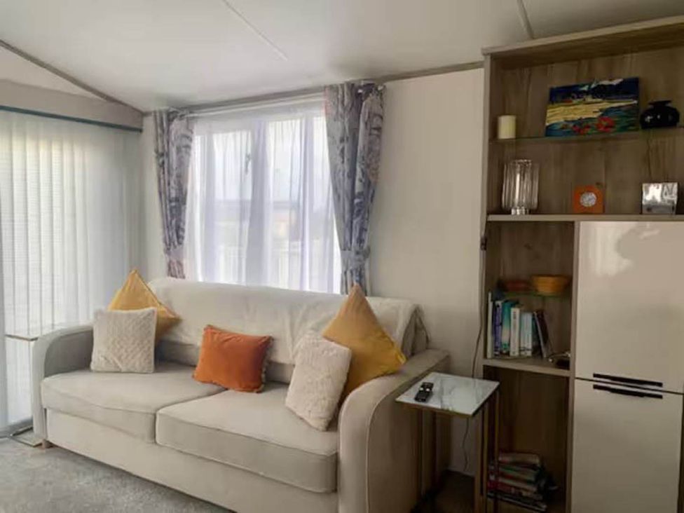 A living room with a sofa and bookshelf at Findhorn Lodge Peaceful Sleeps 4 in Forres