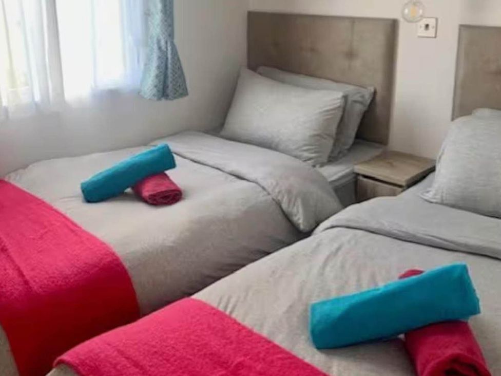 A bedroom with two beds and towels at Findhorn Lodge Peaceful Sleeps 4 in Forres