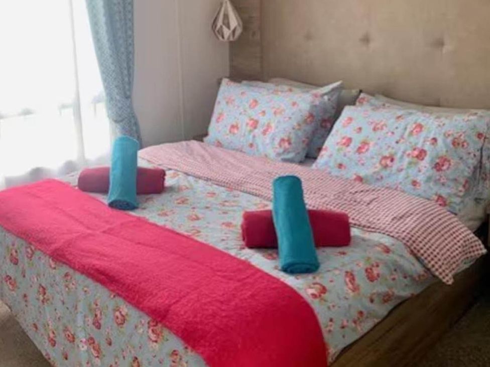 A bedroom with a bed and towels arranged at Findhorn Lodge Peaceful Sleeps 4 in Forres