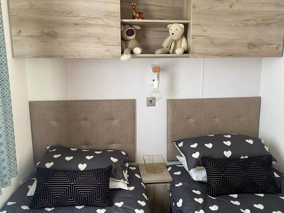 A bedroom with two beds and stuffed animals on a shelf at Findhorn Lodge Peaceful Sleeps 4 in Forres