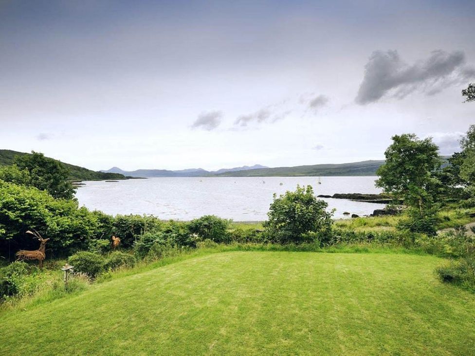 A view of water and mountains with grass in the foreground at Tigh na Mara Sleeps 4 Sea Views Pet Friendly Drimnin near Lochaline