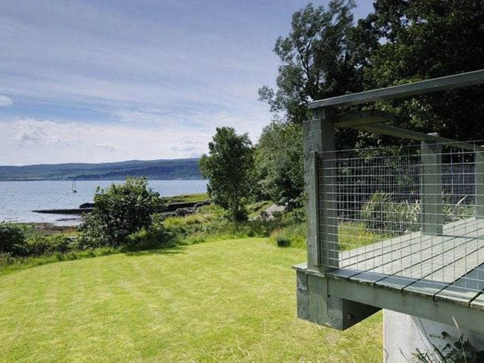 A deck overlooking the water and grass areas at Tigh na Mara Sleeps 4 Sea Views Pet Friendly in Drimnin near Lochaline