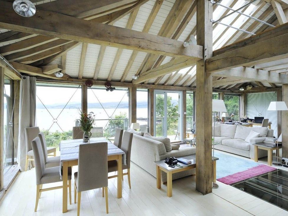 A living room with a dining area and large windows at Tigh na Mara Sleeps 4 Sea Views Pet Friendly Drimnin near Lochaline