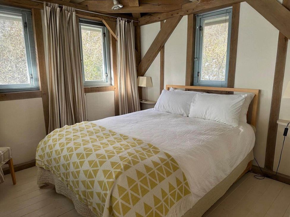 A bedroom with a bed and windows at Tigh na Mara Sleeps 4 Sea Views Pet Friendly in Drimnin near Lochaline