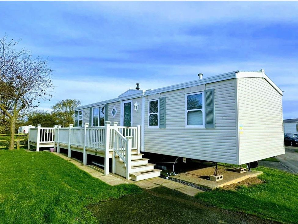 A caravan with a deck and steps at Sea Breeze A Beautiful 3 Bed Pet Friendly Retreat Mablethorpe
