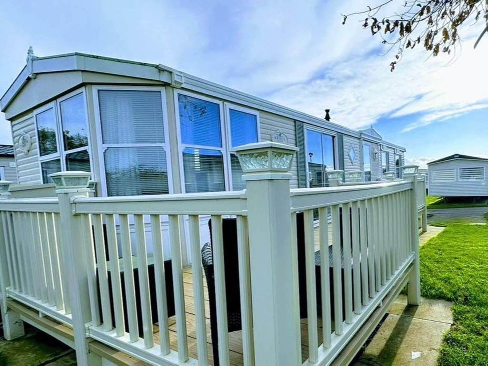 A holiday home with a deck and fence at Sea Breeze A Beautiful 3 Bed Pet Friendly Retreat Mablethorpe