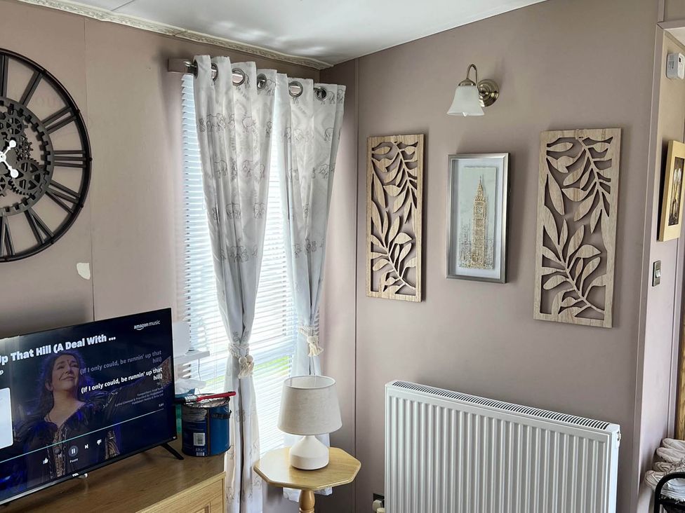A living room with a television and a lamp at Sea Breeze A Beautiful 3 Bed Pet Friendly Retreat Mablethorpe