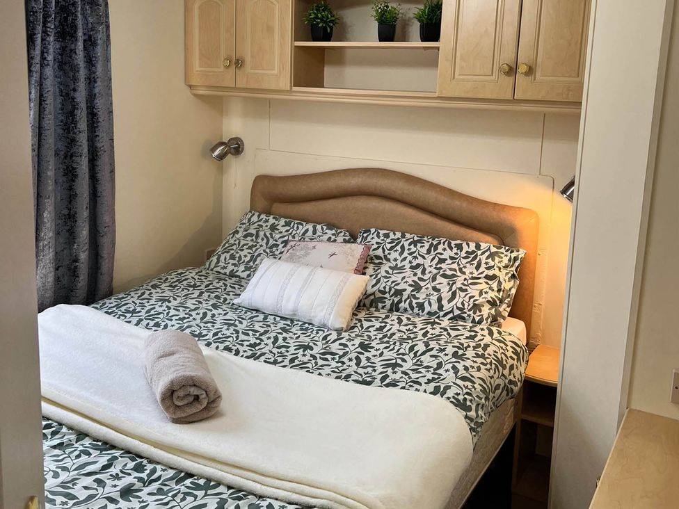 A bedroom with a bed and shelves at Sea Breeze A Beautiful 3 Bed Pet Friendly Retreat in Mablethorpe