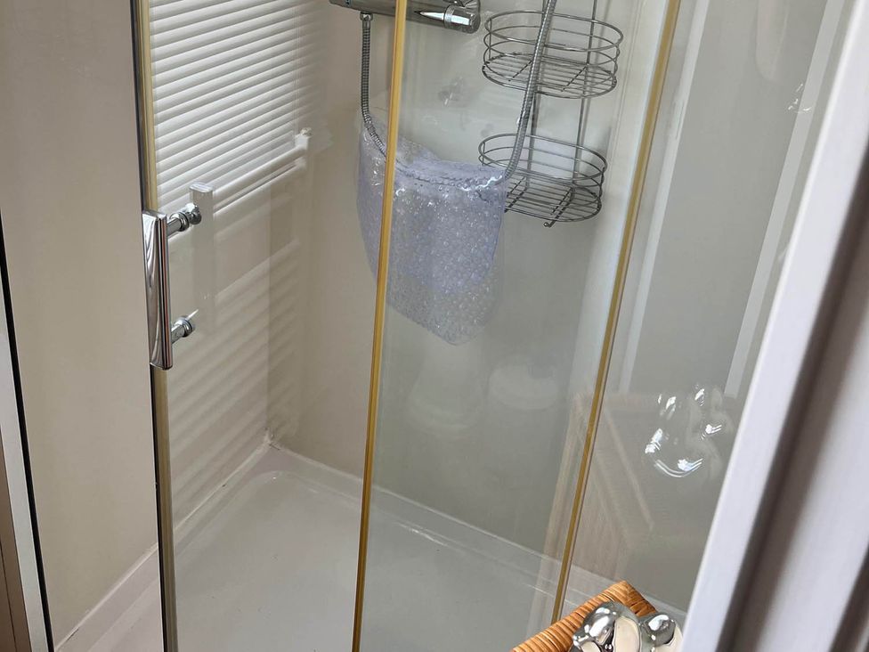 A shower with a glass door and shelves in the bathroom at Sea Breeze A Beautiful 3 Bed Pet Friendly Retreat Mablethorpe