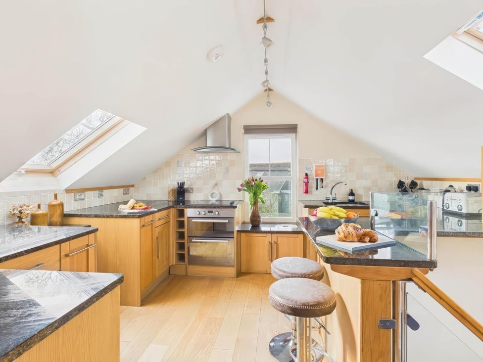 A kitchen with countertops and bar stools at Apartment Sleeps 4 Enclosed Garden Pets Welcome Flushing