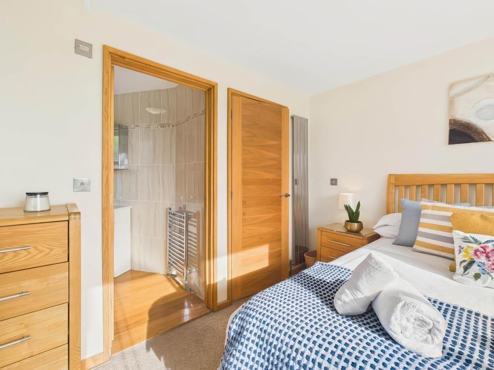 A bedroom with a bed and a shower room at Apartment Sleeps 4 Enclosed Garden Pets Welcome in Flushing