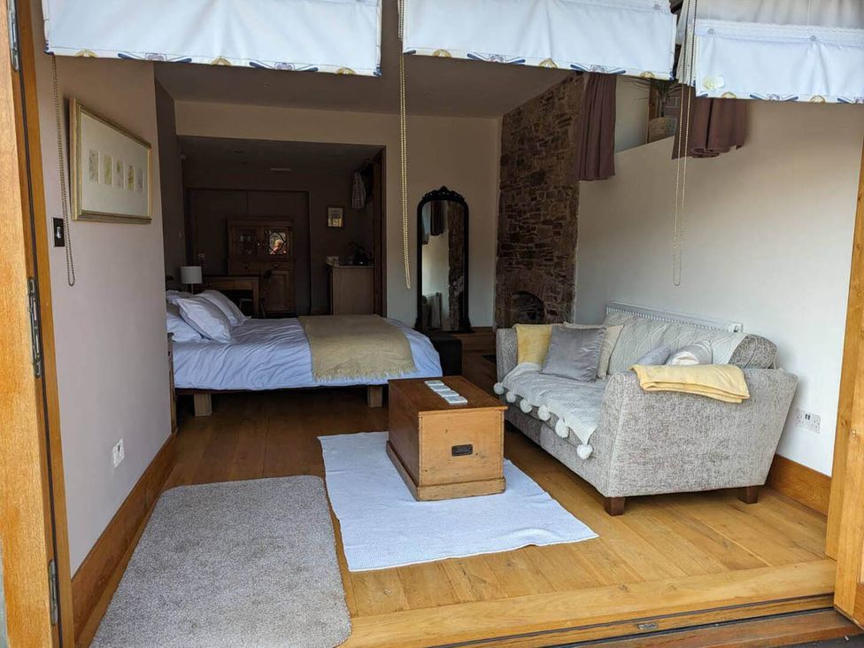 A living room with a bed and sofa at The Old Chapel of Ermington Converted Vestry in Ermington