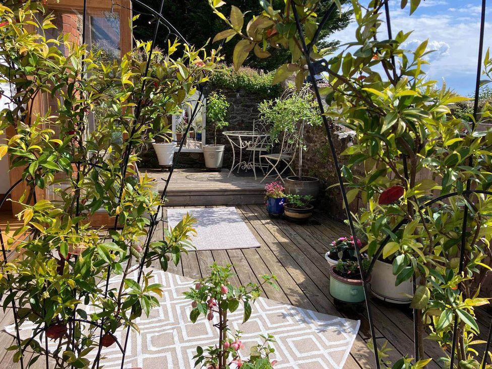 A garden with wooden deck and furniture at The Old Chapel of Ermington in Ermington
