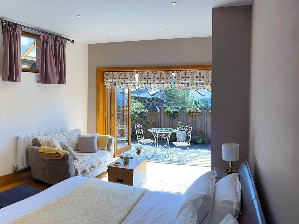 A bedroom with a sofa and a view of outdoor seating at Old Chapel of Ermington Converted Vestry in Ermington