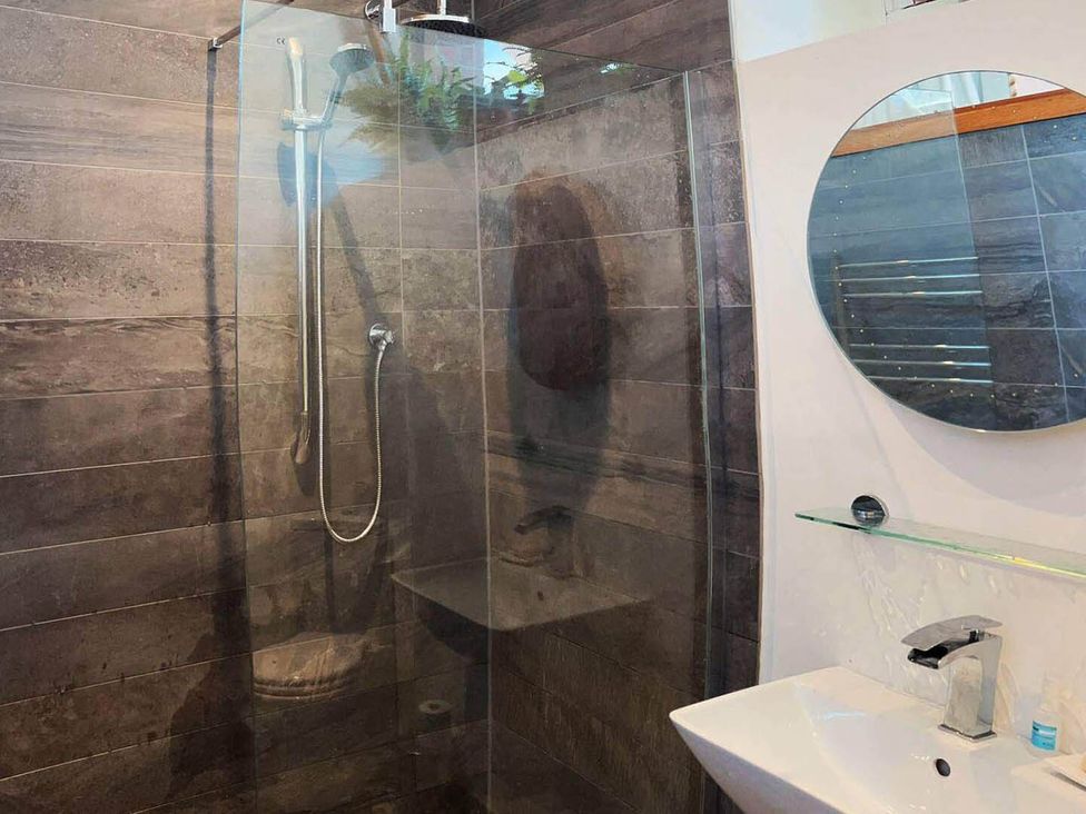 A bathroom with a shower, sink, and mirror at Old Chapel of Ermington Converted Vestry in Ermington