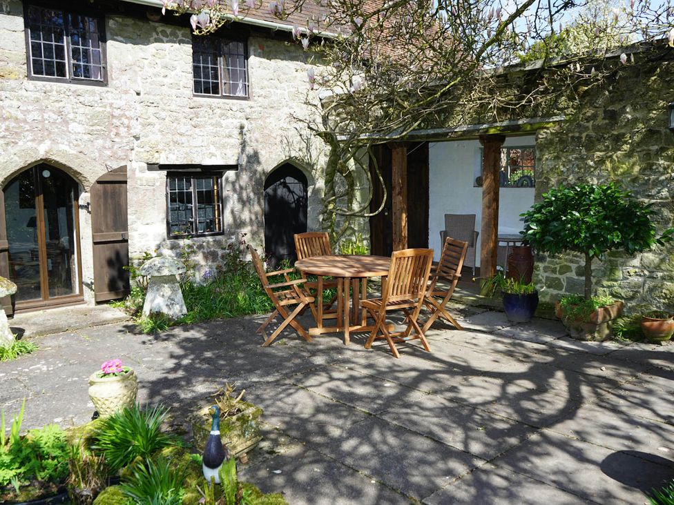 An outdoor area with a table and chairs near a stone wall at The Old Barn in Manchester