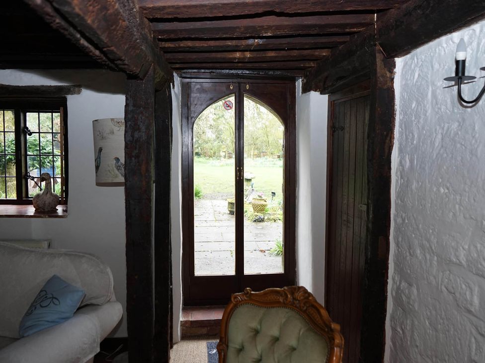 A living room with a window and door leading to the garden at the property in 