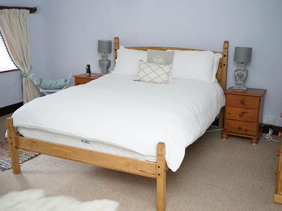 A bedroom with a bed and two nightstands at the property