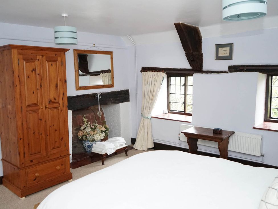 A bedroom with a wardrobe and a table at The Old Barn in Manchester