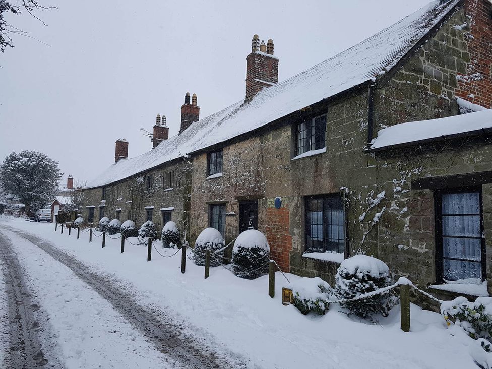 A row of houses covered in snow along a road