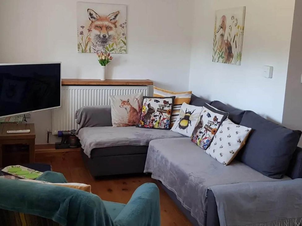 A living room with a sofa and television at 3 Bedroom Cottage Hot Tub Garden Parking Dunkeswell